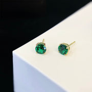 Round cut emerald stone earrings.